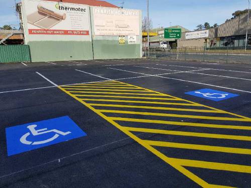 A parking lot featuring clearly marked handicap parking signs for accessible vehicle parking.