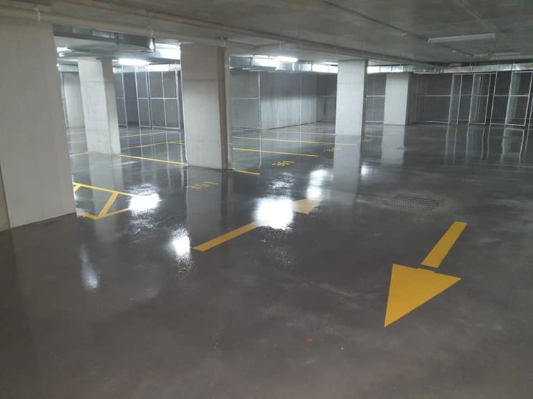 An image of a parking garage with yellow arrows pointing left.