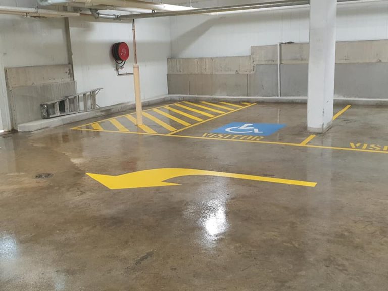 A parking garage featuring yellow arrows directing to the right.